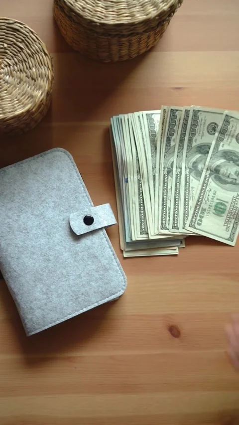 Hand spreading one hundred dollar bills on wooden table Stock Footage 331772036
