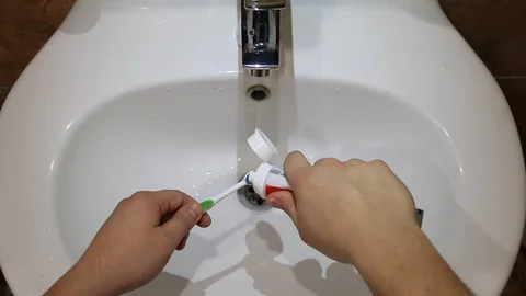 Hand spreading toothpaste on a toothbrush Vídeo Stock 113010745