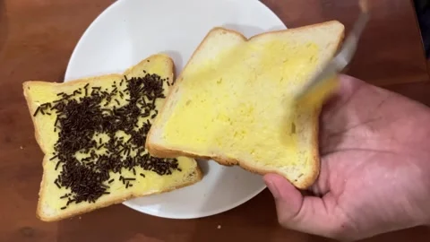 Hand spreading yellow butter on slice of white bread Vídeos de archivo 346681399