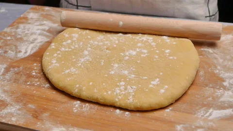Hand sprinkle the flour onto the dough, preparing for the homemade pizza. Видео 158092301