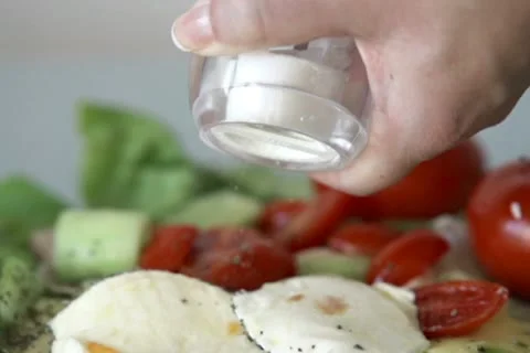 Hand sprinkle salt on mozzarella cheese, slow motion shot at 480fps NTSC Stock Footage 12369012