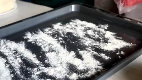Hand sprinkles flour on a tray Video stock 159442420