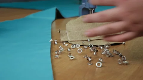 Hand Sprinkles Metal Rivets on Table. Clothes Sewing Workshop. Metallic Grips Stock Footage 146107145