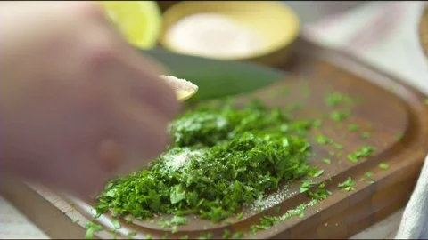 Hand sprinkling salt over chopped herbs Stock Footage
