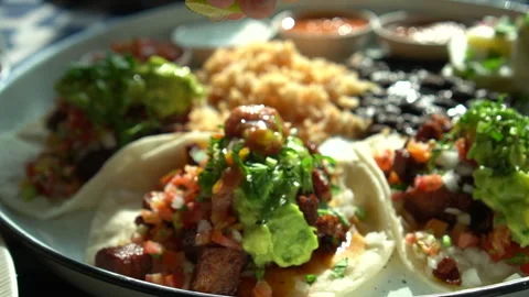 Hand sqeezing lime lemon over soft carnitas avocado taco Mexican salsa food Stock Footage 258344407