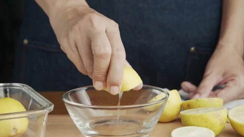 Hand squeeze fresh lemon, juice drains from the pulp and drips. Squeezing out Stock-Footage 336588846