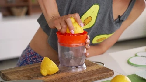 Hand squeeze fresh lemon. Lemon juice drains from the pulp and drips. Stock Footage 111443816