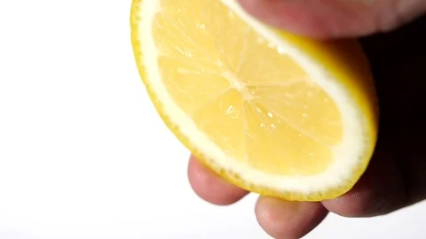 Hand squeeze fresh lemon in slow motion on white background Video stock 126953295