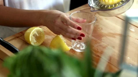 Hand with Squeezer Squeezing Lemon Juice out of lemon. Yellow vibrant color. Stock Footage 265838620