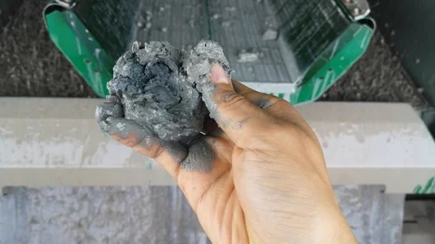 A hand squeezes cutting coming from a shale shaker Stock Footage 100877113