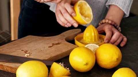 Hand squeezes lemon juice on squeezer in close up. Lemon being pressed and juice Stock-Footage 336588799