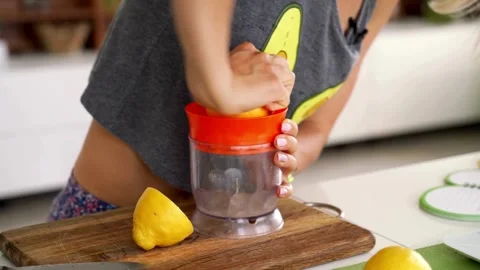 Hand squeezes lemon juice on squeezer in close up. Lemon being pressed and juice Stock-Footage 336588839