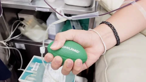 The hand squeezes the rubber ball to make the blood circulate better. Stock Footage 223378876