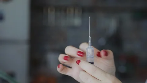 Hand squeezes some of the liquid from the syringe Stock Footage 122443198