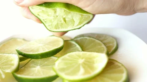 Hand squeezes squeezing juice of half a lime Video stock 133559955
