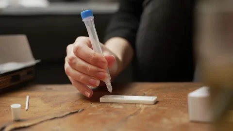 Hand squeezing Antigen Covid-19 home test tube to check coronavirus results Stock Footage 169099361
