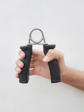 Hand squeezing a black hand gripper Stock Photos