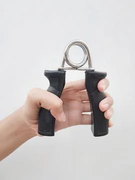 Hand squeezing a black hand gripper Stock Photos
