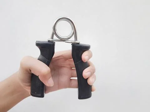 Hand squeezing a black hand gripper Stock Photos