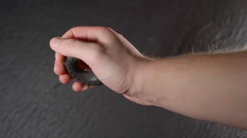 Hand squeezing a black rubber expander, close-up Stock Footage 322170507