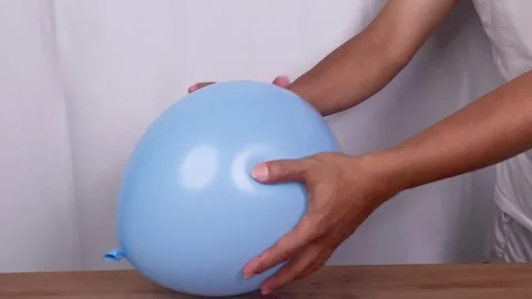 Hand squeezing blue rubber balloon Video stock 345586284