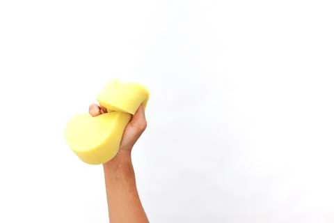 Hand Squeezing a Bright Yellow Sponge Against a Clean White Background Stock Photos