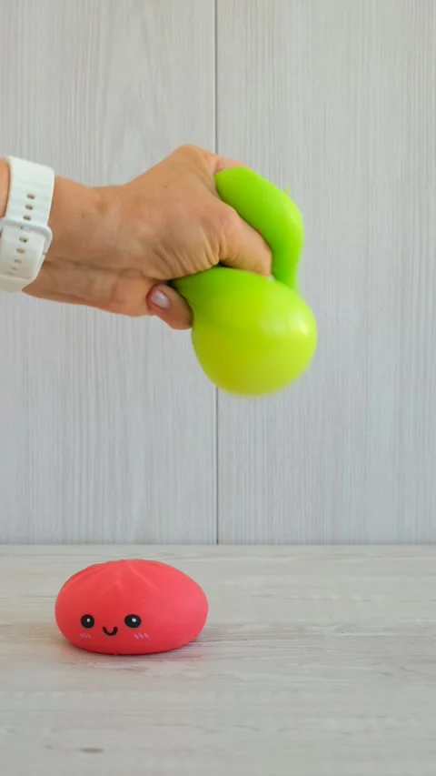 Hand squeezing cute green soft anti-stress toys in the shape of a dumpling Stock Footage 347071270