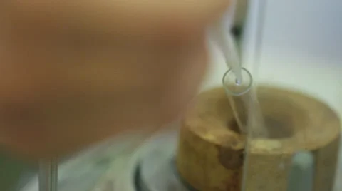 Hand squeezing a dripper into a test tube. Video stock 37987623