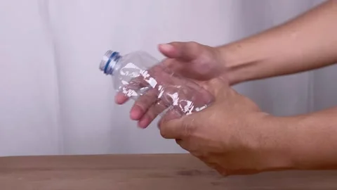 Hand Squeezing Empty Plastic Bottle Stock Footage 345586295