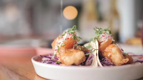 Hand Squeezing Fresh Lime Over Delicious Fish Tacos at a Restaurant Stock Footage 305022133