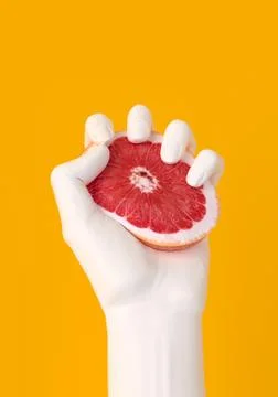 Hand squeezing grapefruit, citrus fruit slice isolated on yellow. Summer mood Stock Illustration
