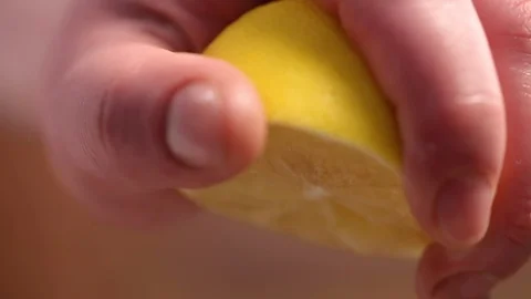 Hand squeezing half of lemon on white background Stock Footage 122095711