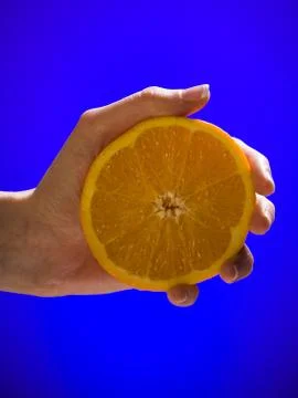 Hand squeezing half an orange Stock Photos