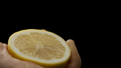 A hand squeezing the juice from a lemon half 動画素材 128721088