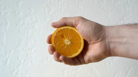 Hand squeezing a juicy orange Stock Footage 127282894
