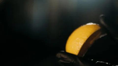 Hand squeezing a lemon on dark Stock Footage 125458414