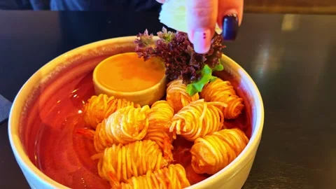 Hand Squeezing Lemon Over Spiral Potatoes Видео 333314917
