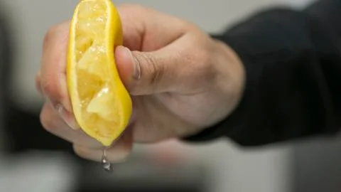 A hand squeezing a lemon. Foto stock