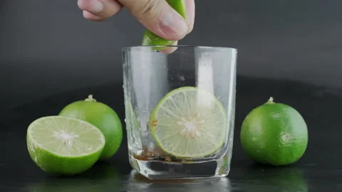 Hand squeezing lime into a glass with Stock Video Pond5