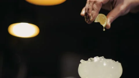 Hand squeezing must from a slice of lemon in a glass Video stock 144002855