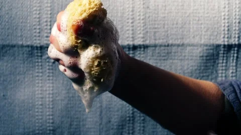 Hand squeezing natural sponge water soapy suds water Stock Footage 270085246