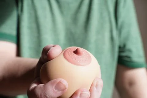 Hand squeezing or groping boob shaped anti-stress ball Foto stock