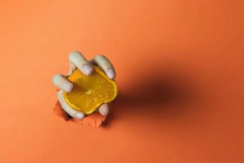 Hand squeezing an orange. Abstract concept Stock Photos