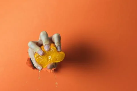 Hand squeezing an orange. Abstract concept Stock Photos