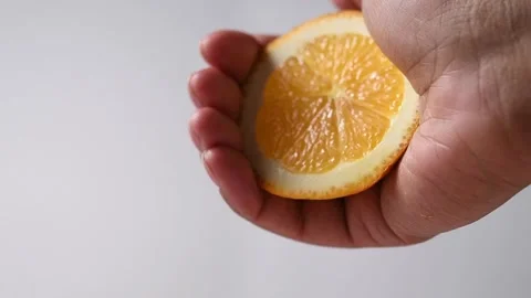 Hand squeezing orange juice. Stock Footage 131998458