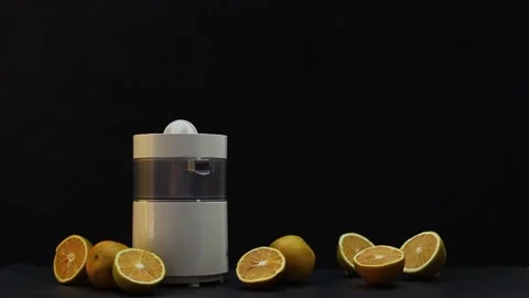Hand squeezing oranges on a black background Stock Footage 131250994