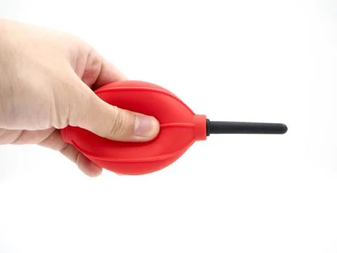 Hand squeezing a red camera air blower isolated on a white background. Stock Photos