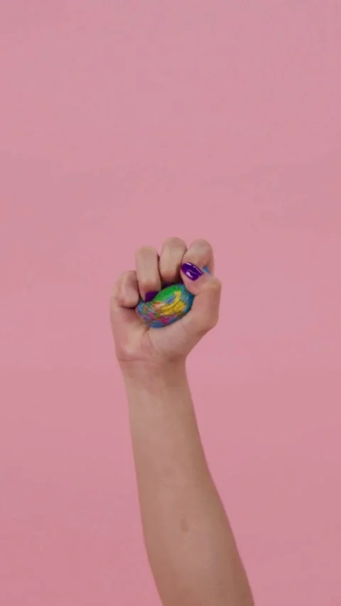 Hand squeezing a small earth globe stress ball toy Stock Footage 331773895