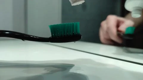 Hand squeezing toothpaste on toothbrush Stock-Footage 146243916