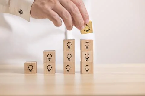 Hand stack wooden blocks with thinking and idea icon to graph. Concept for cr Stock Photos